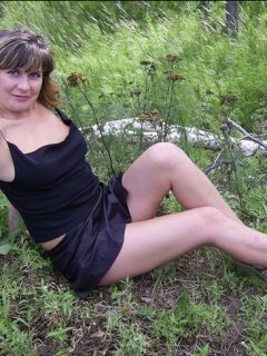 Русская женщина раздевается в лесу и позирует голой